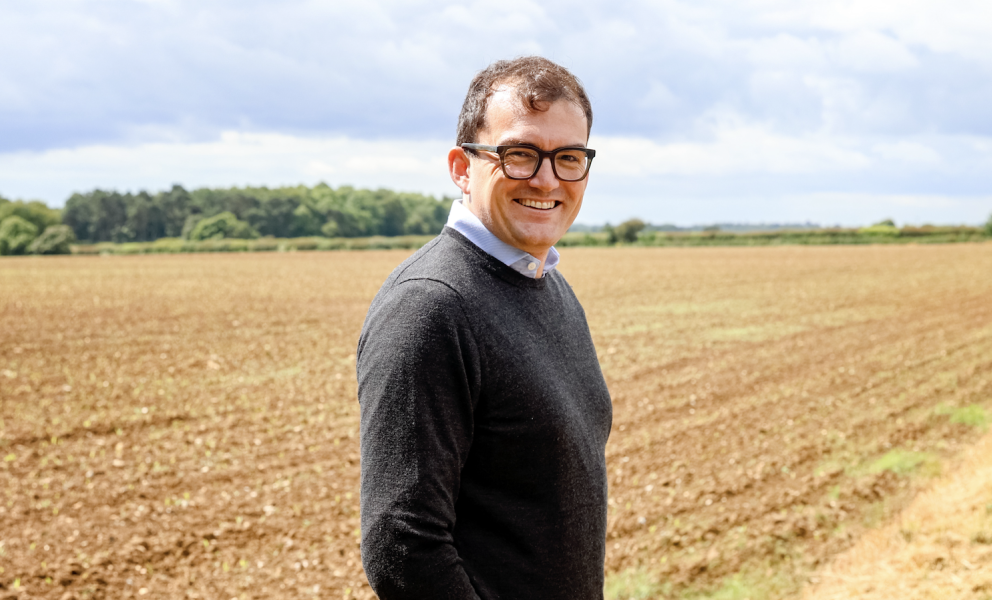 Patrick Spencer MP standing in a harvested field